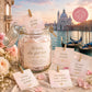 Glas mit gefalteten Affirmationskarten und Etikett „Worte, die gut tun“ vor venezianischer Kulisse mit Rosen – Divine Whispers Affirmationen im Glas